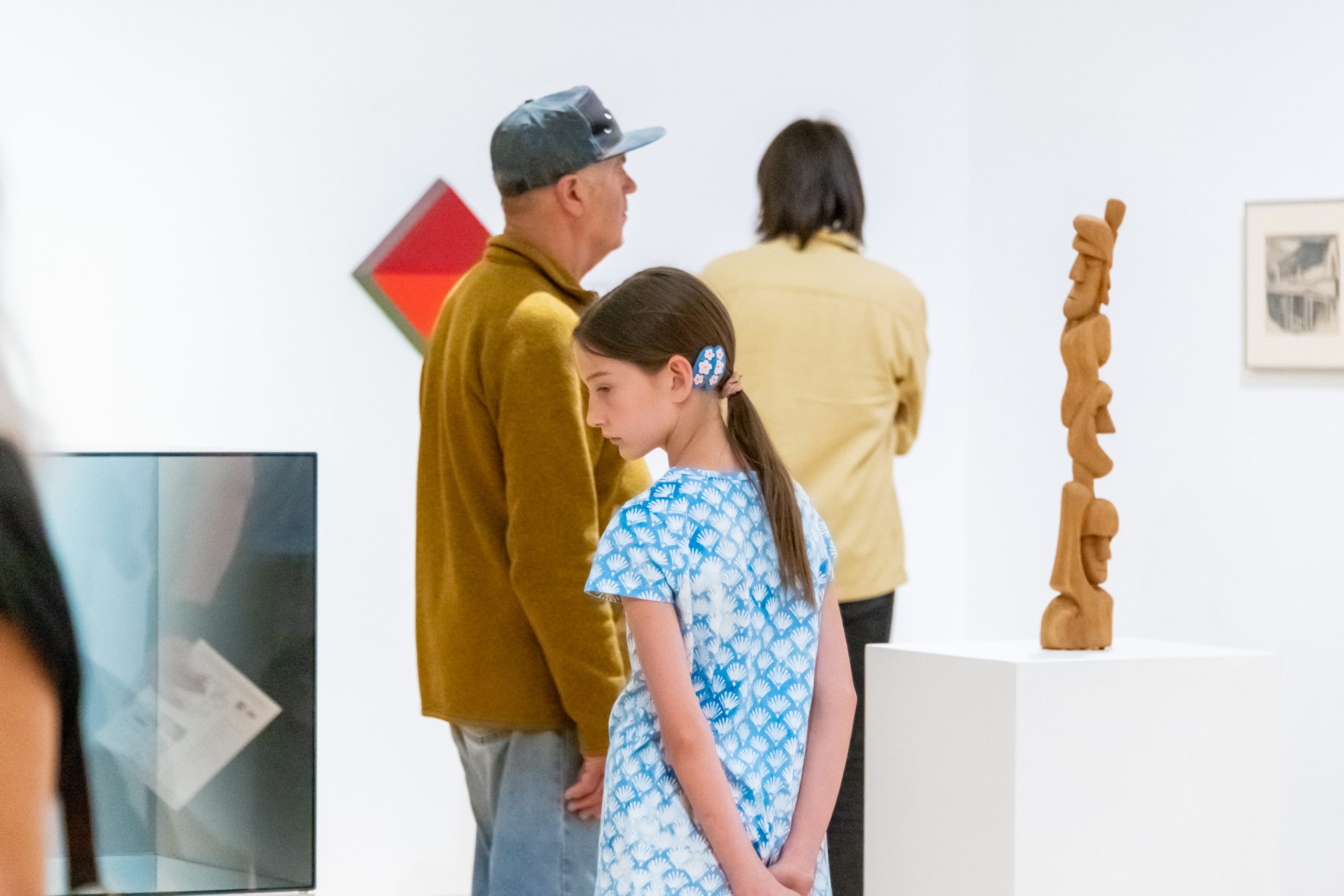 Three generations of visitors look at art at the Harwood.