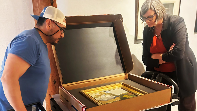 two people looking at some art in a box
