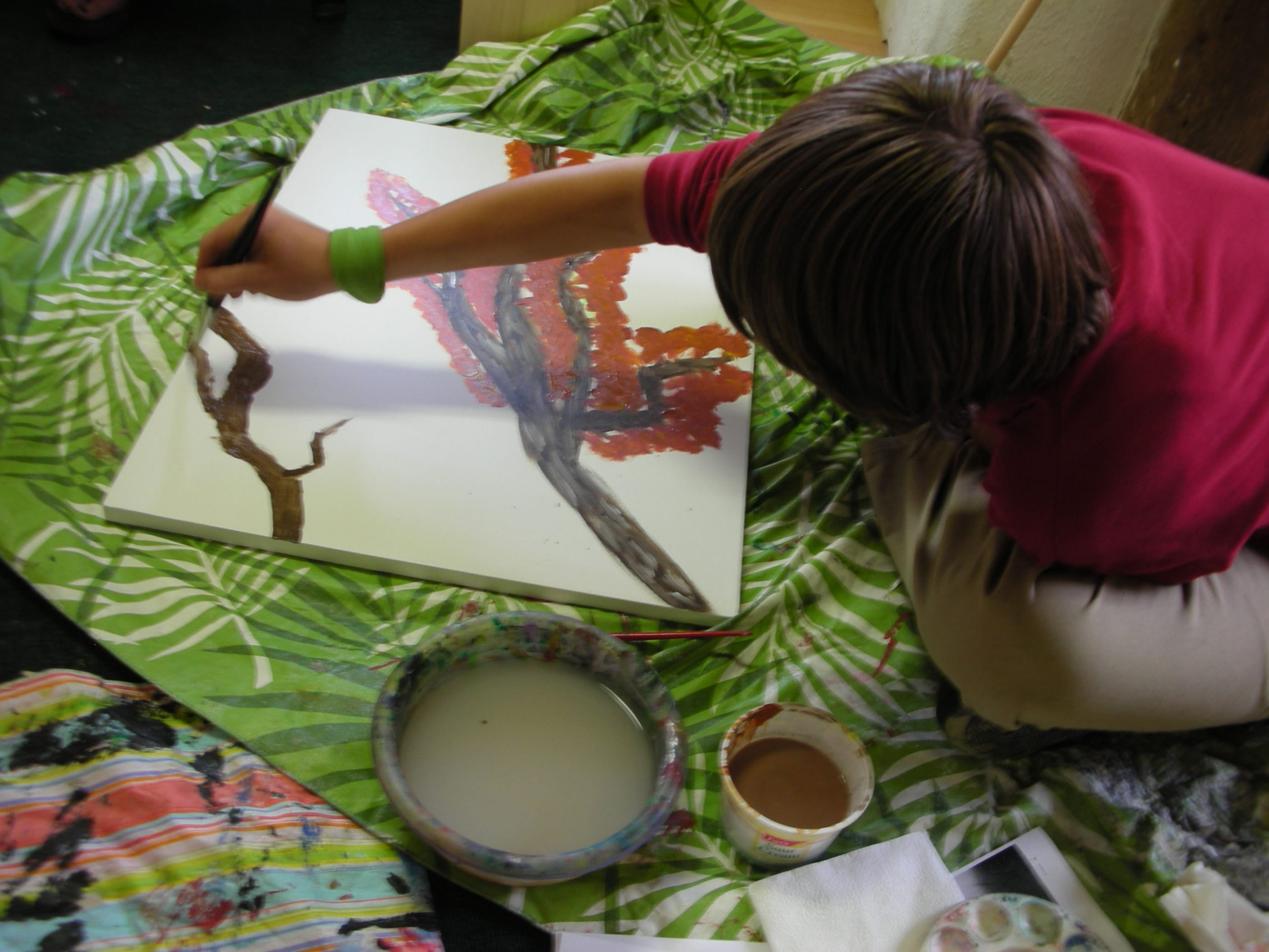 a child painting a picture of a tree