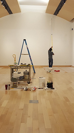 a harwood worker prepping the gallery