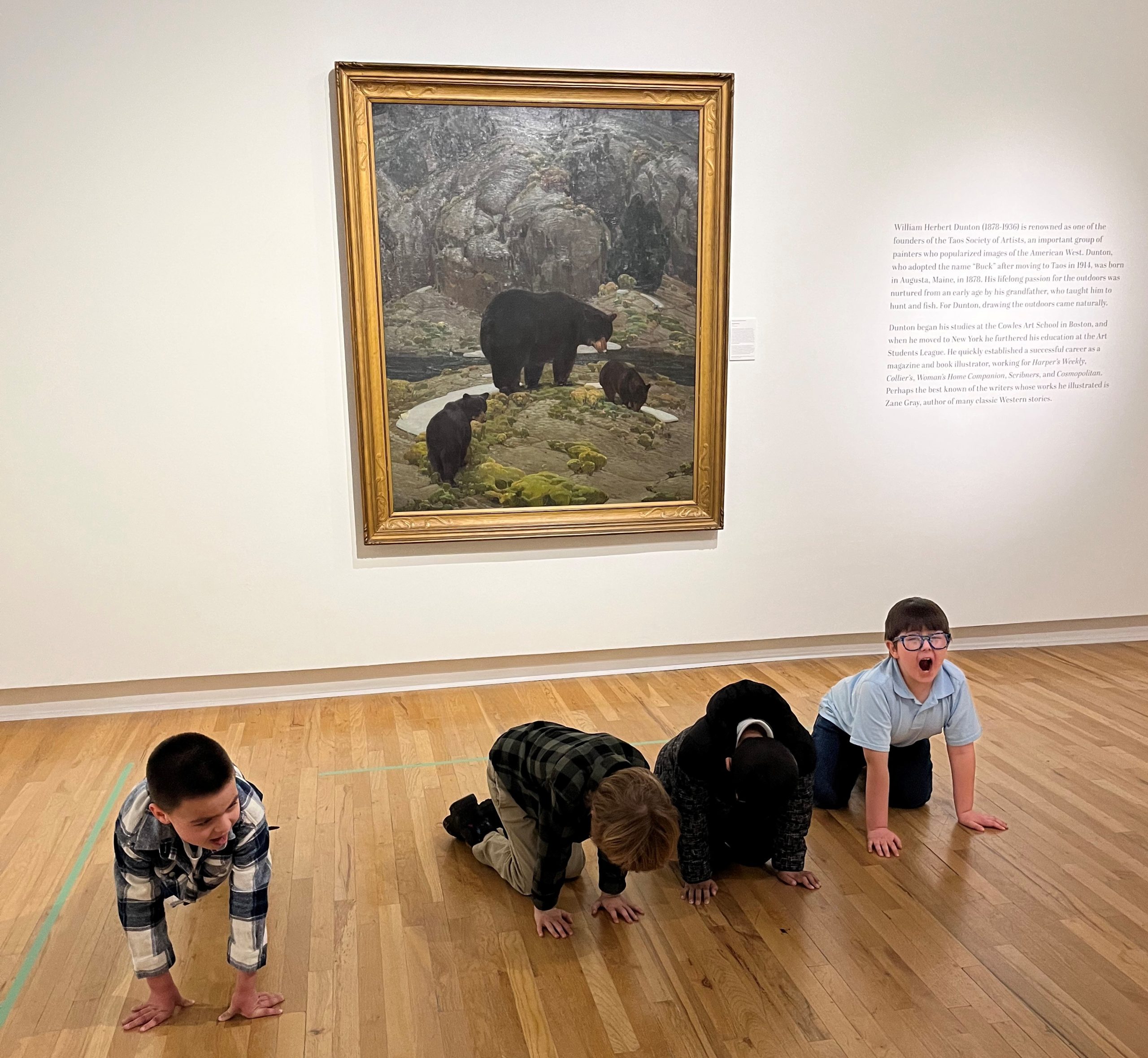 Four children pose in front of a Buck Dunton painting of black bears.