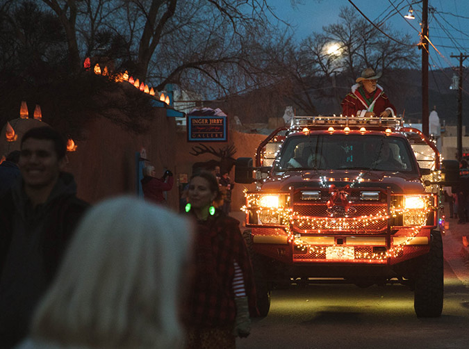 Evening street scene with fire truck covered in Christmas lights