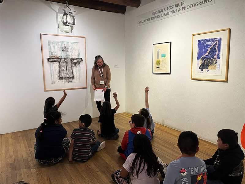 a Harwood teacher leads a school tour of seated young students