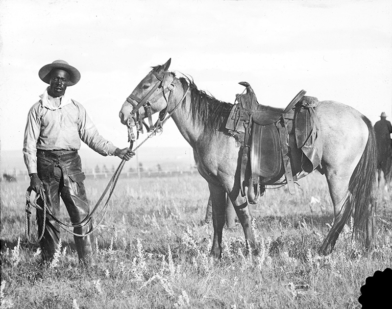 black and white photo of cowboy with horse