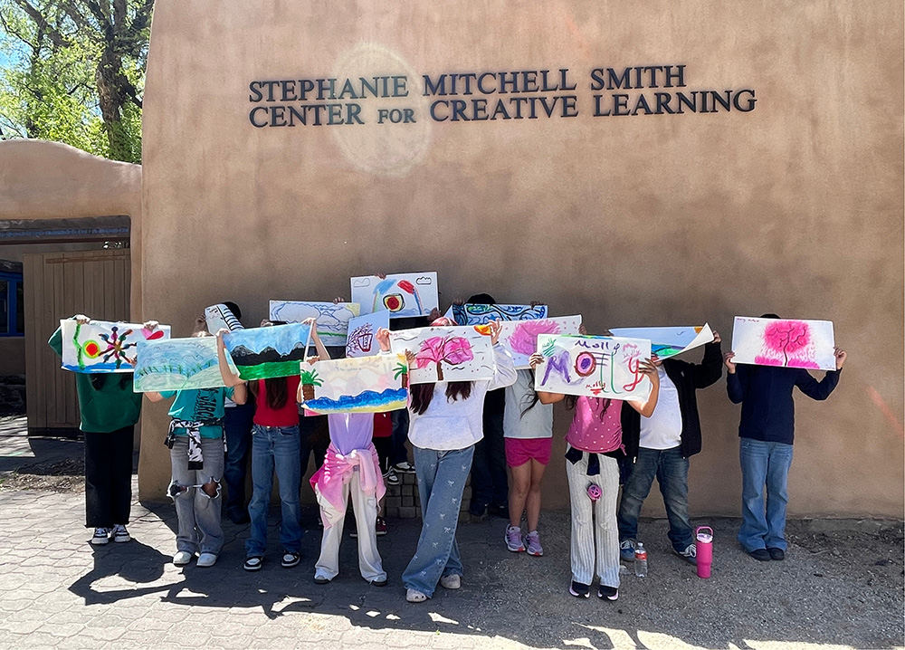 students group picture all holding up artwork